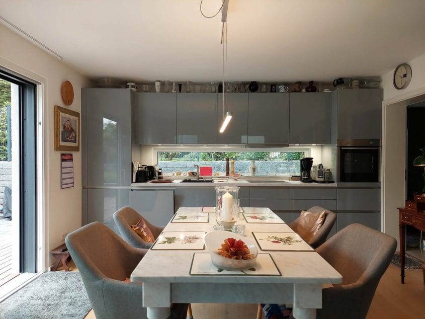 Anbau und Interieur-Konzept, Ratingen — Offene Küche mit Hochglanzfronten und gedecktem Esstisch im Vordergrund