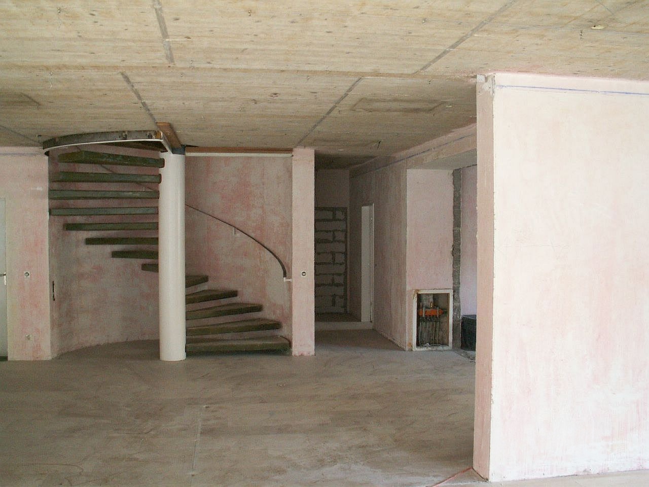 Wendeltreppe und offene Leitungen im Rohbau der früheren Büroetage