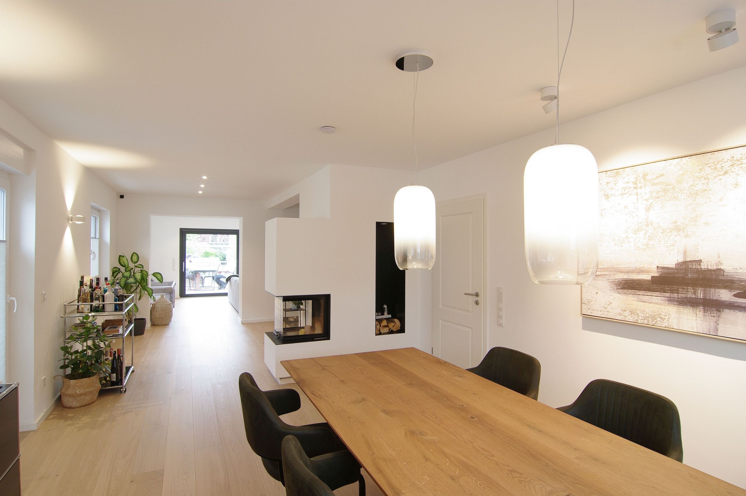 Essbereich mit Holztisch und dreiseitigem Kamin nach dem Hausumbau in Ratingen — Innenarchitektur von Bernd Schüller