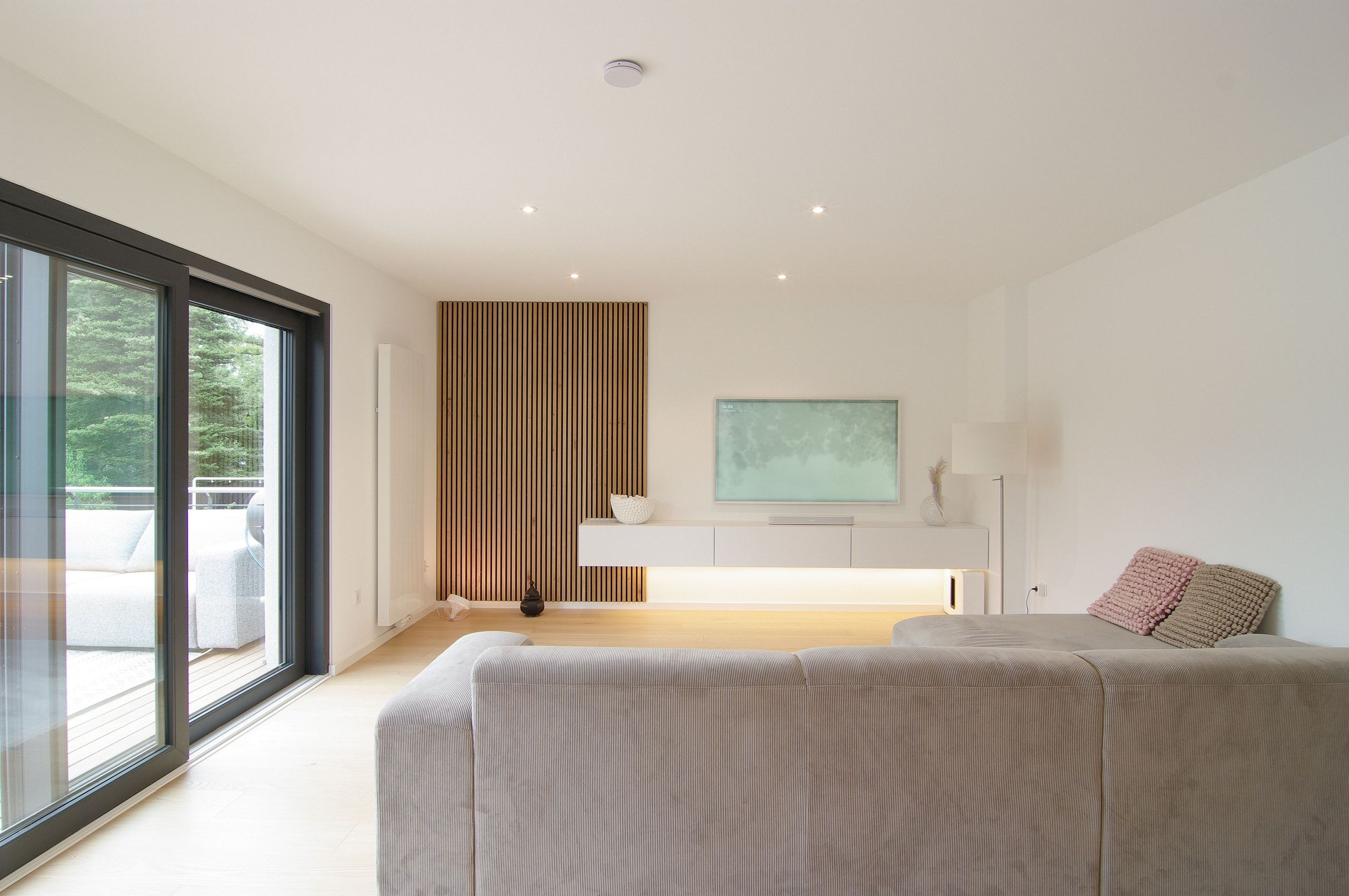 Wohnbereich mit Terrassentür, Holzlamellenwand und schwebendem Sideboard in Ratingen — Innenarchitektur von Bernd Schüller