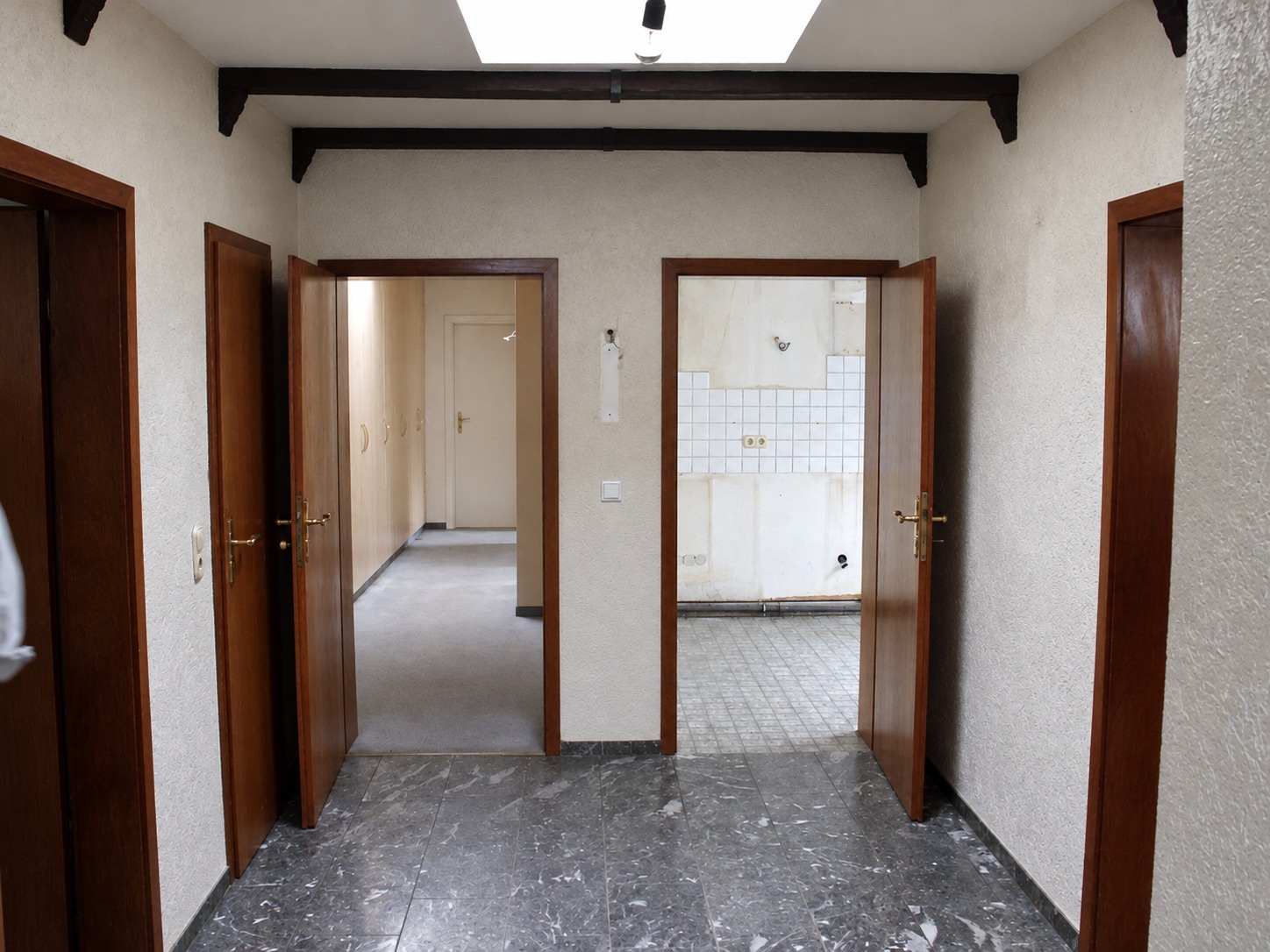 Bestehende Diele mit Holztüren und Blick in das ehemalige Bad